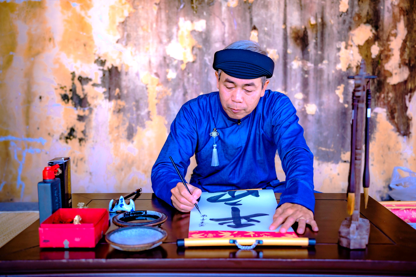 “Thầy đồ” Nguyễn Phước Hải Trung - Phó Giám đốc Trung tâm Bảo tồn Di tích Huế, cho chữ người du Xuân đầu năm trong Đại nội. Ảnh: Đình Hoàng