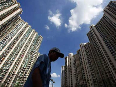 Một người lao động nghèo đi ngang qua khu nhà cao tầng ở Thượng Hải. Ảnh: China Daily