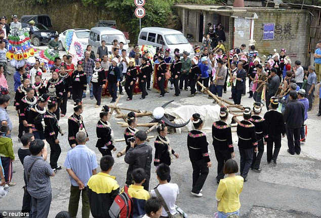 Người dân làm lễ cho chú trâu này trước khi đem đi chôn. Ảnh: Reuters Người dân làm lễ cho chú trâu này trước khi đem đi chôn