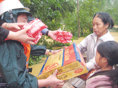 Lũ vây bọc, bà Nguyễn Thị Lệ và con gái (thôn 5, Phương Mỹ, Hương Khê, Hà Tĩnh) phải nhờ đến hàng cứu trợ để cầm cự chờ nước rút. Ảnh: Minh Thùy