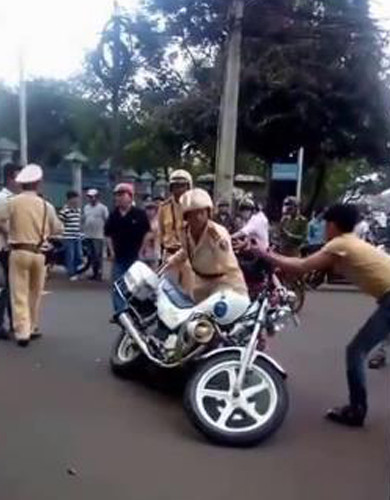 Nam thanh niên này cố kéo chiếc xe đặc chủng nằm nguyên tại hiện trường nhưng bị đuổi ra. Ảnh: cắt từ video. Nam thanh niên này cố kéo chiếc xe đặc chủng nằm nguyên tại hiện trường nhưng bị đuổi ra. Ảnh: cắt từ video