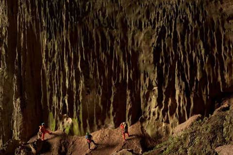 Giống như một thác nước hóa đá, những dải thạch nhũ gần cửa hang Én mang màu xanh của rêu và tảo
