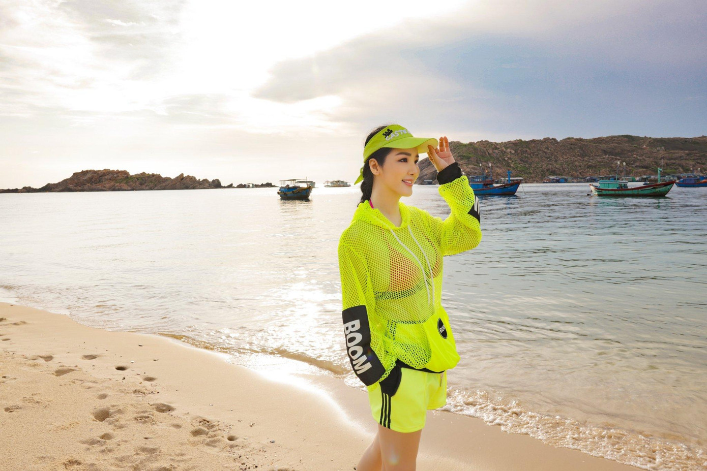 Hoa hậu Giáng My diện trang phục thể thao có màu sắc sặc sỡ trên biển.