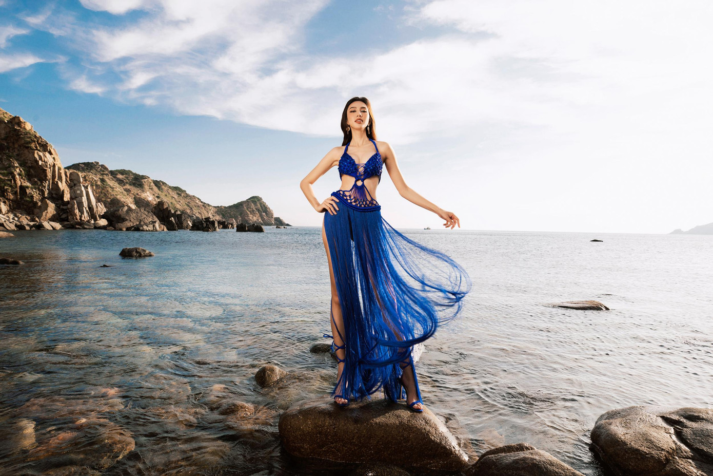 Hoa hậu Thùy Tiên khoe dáng với bộ váy tua rua màu xanh cùng những khoảng cut-out nóng bỏng.