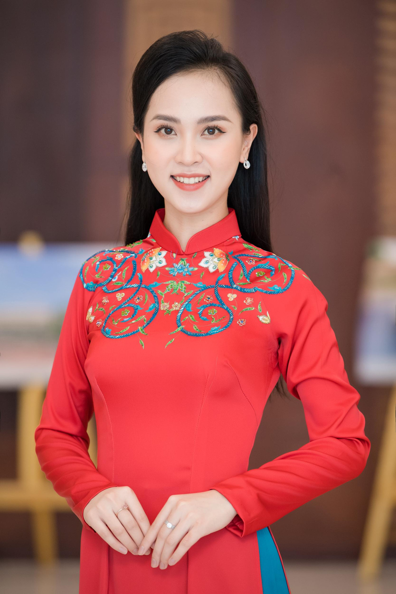 Người đẹp Diệu Ngân yêu kiều với áo dài màu đỏ thêu họa tiết cầu kỳ.