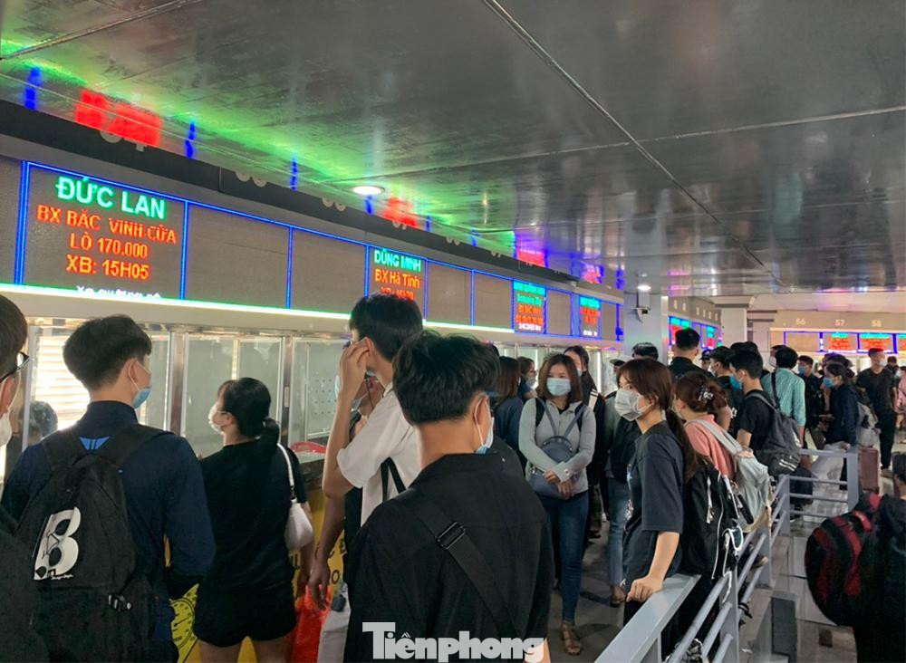 Bên trong phòng vé tại bến xe Nước Ngầm, người dân đứng ngồi chờ mua vé rất đông