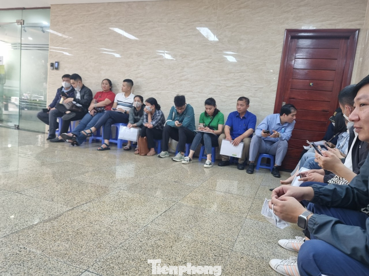 Người dân vạ vật ngồi xếp hàng chờ nộp hồ sơ mua nhà ở xã hội (ảnh: Ngọc Mai).