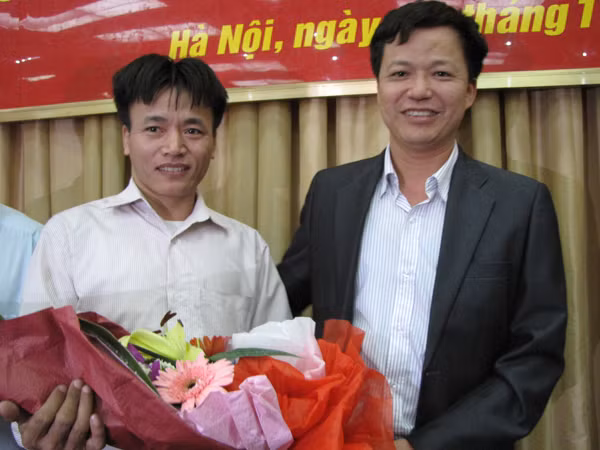 Anh Nguyễn Xuân Việt nhận bó hoa tri ân của anh Phạm Xuân Chiều - bố cháu bé bị bắt cóc. Ảnh: Lãng Phong