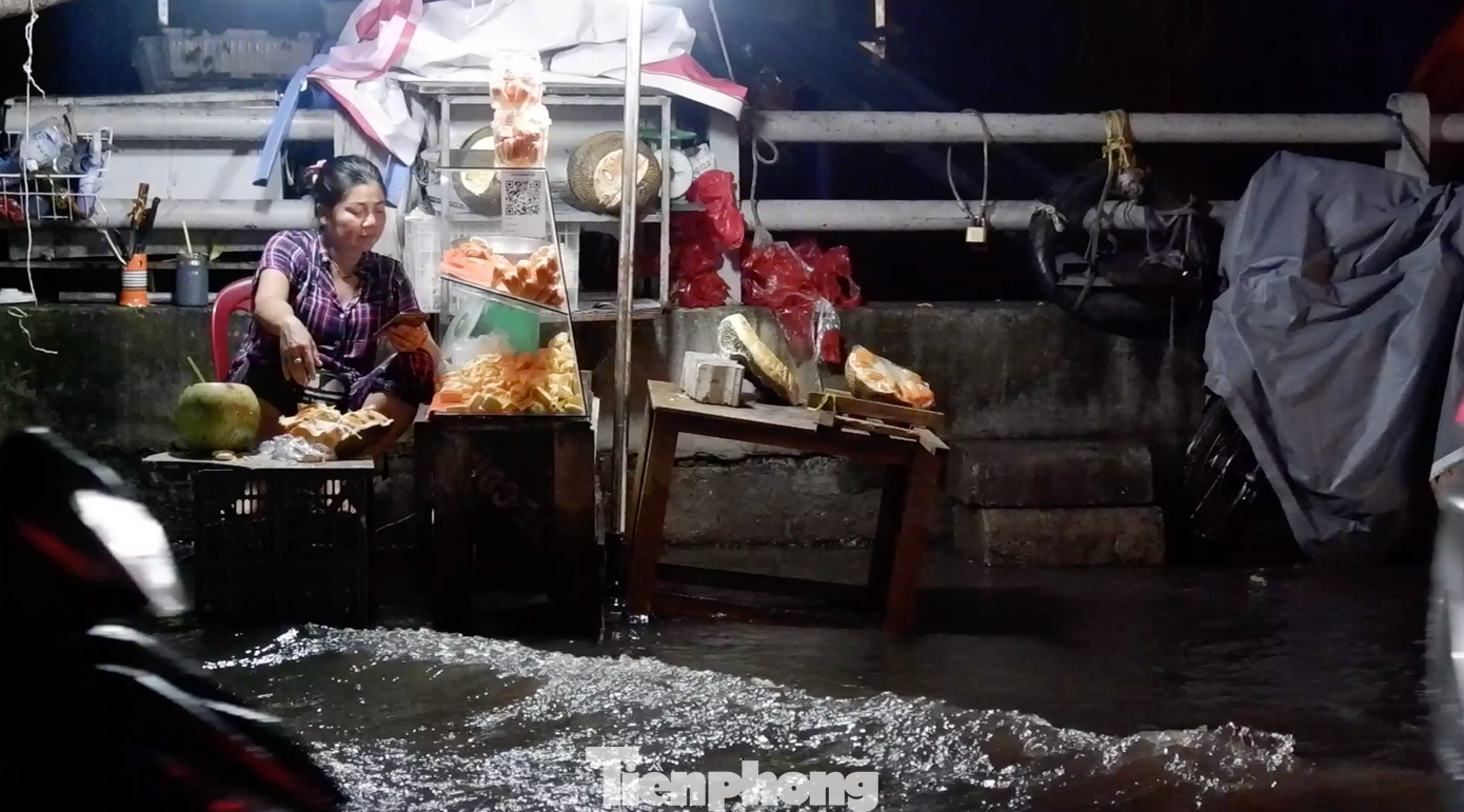 Nước ngập sâu khiến việc buôn bán của tiểu thương bị ảnh hưởng.