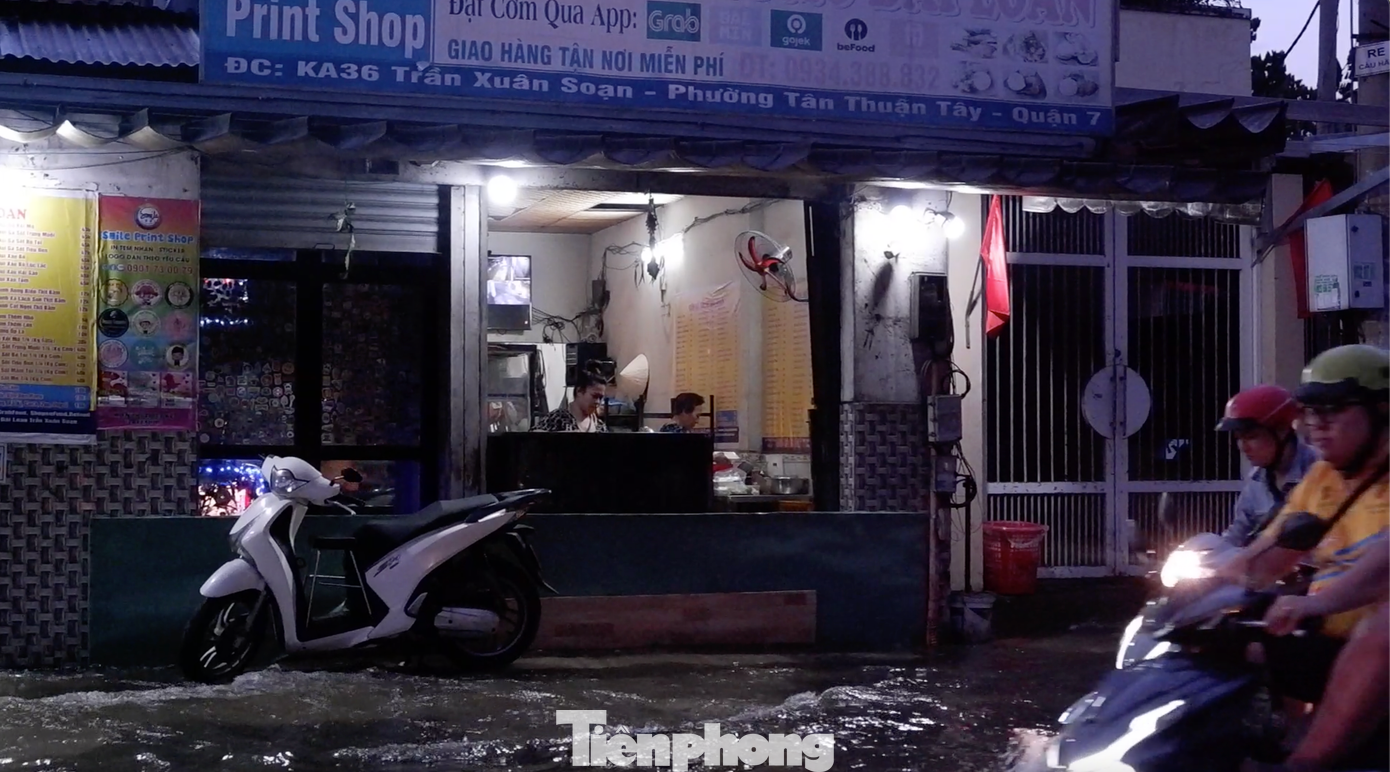 Một cửa hàng trên đường Trần Xuân Soạn phải lắp vách ngăn nước tràn vào nhà.