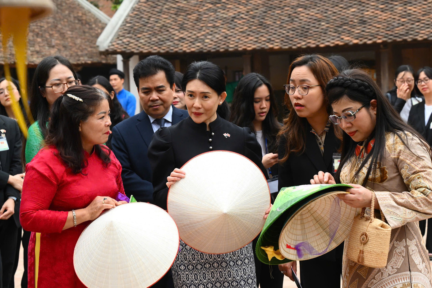 Phu nhân Thủ tướng Singapore Loo Tze Lui được nghe giới thiệu về nón lá. Ảnh: Nhật Minh.