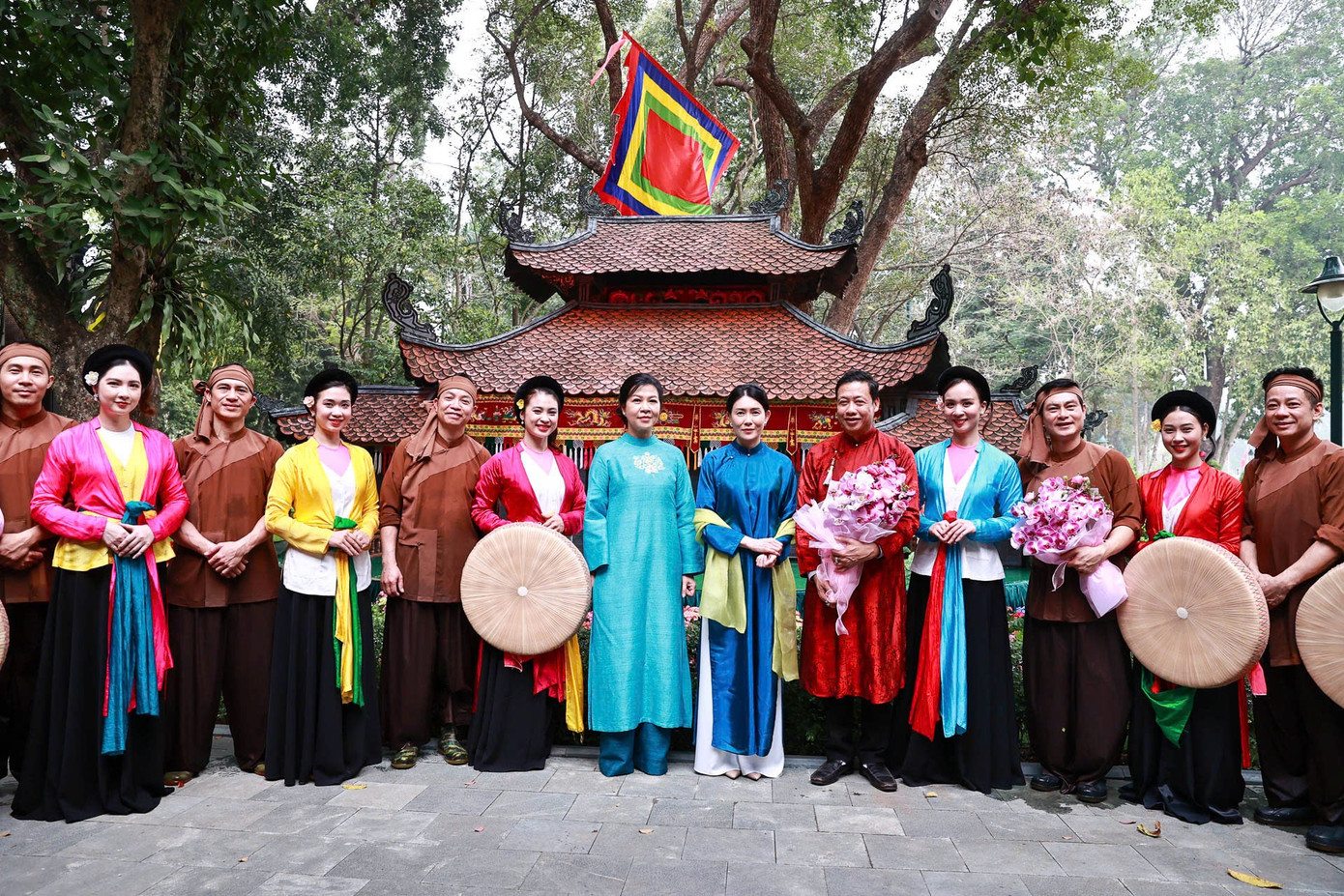 Hai phu nhân chụp ảnh chung với các nghệ sĩ biểu diễn nghệ thuật dân gian. Ảnh: Nhật Minh.