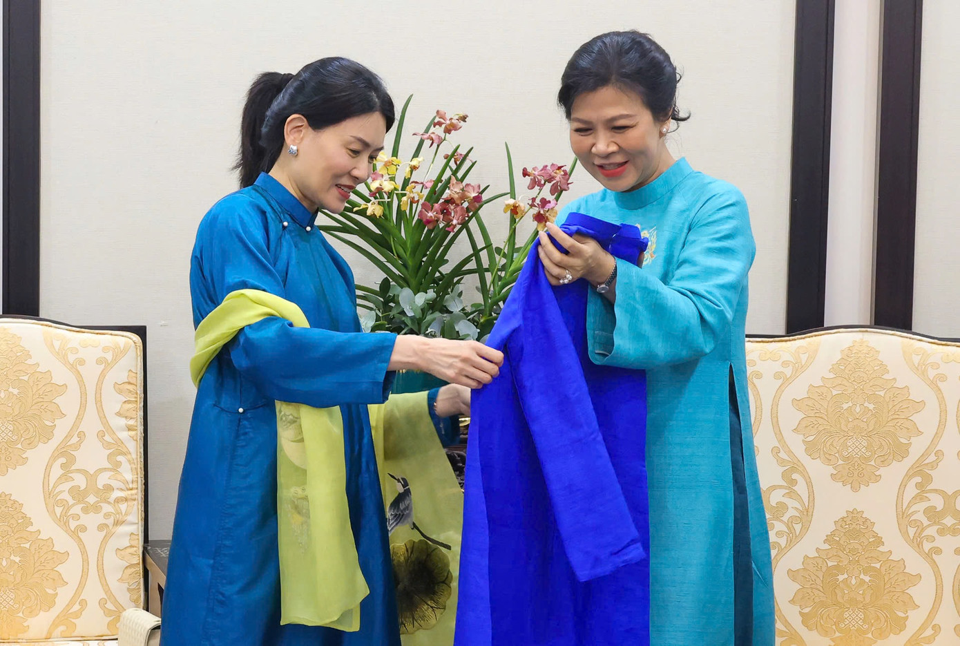 Phu nhân Ngô Phương Ly giới thiệu về phương pháp dệt vải và trân trọng tặng Phu nhân Loo Tze Lui bộ áo dài truyền thống. Ảnh: Nhật Minh.