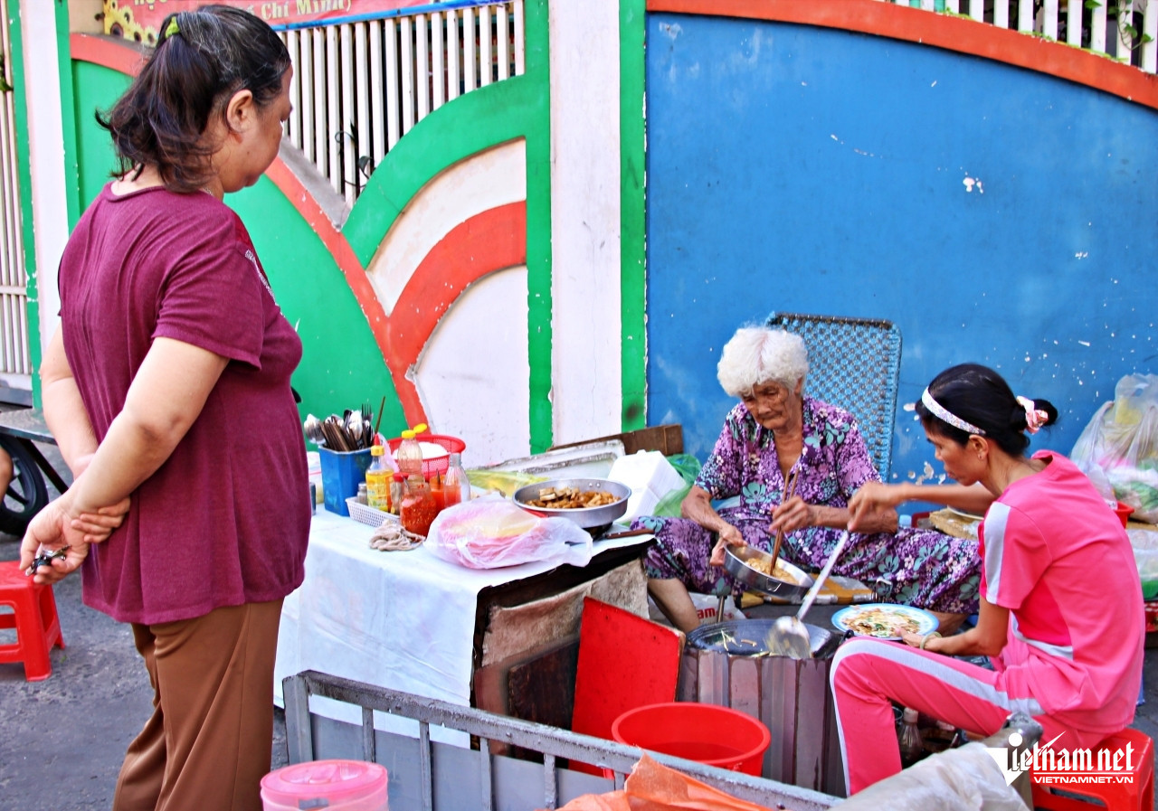 Người khách vãng lai chờ đợi phần ăn của mình chia sẻ, món ăn ở đây có giá bình dân nhưng rất ngon. Ảnh: Hà Nguyễn