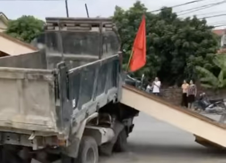 Toàn bộ khối xi măng ở phần trên của cổng nhà văn hoá đổ sấp xuống ca bin xe (Ảnh cắt từ clip).