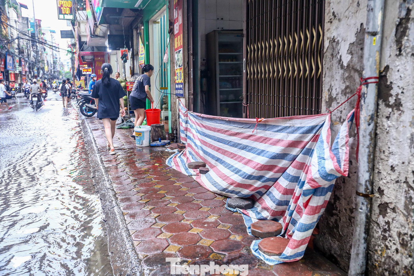 Người dân căng bạt để ngăn cho không cho nước vào nhà.