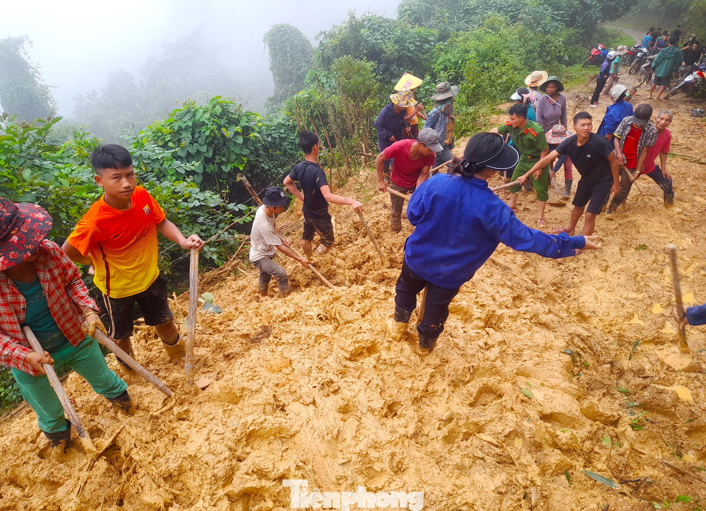 Người dân được huy động cào vét bùn sạt lở để thông đường giao thông cho bà con đi lại.