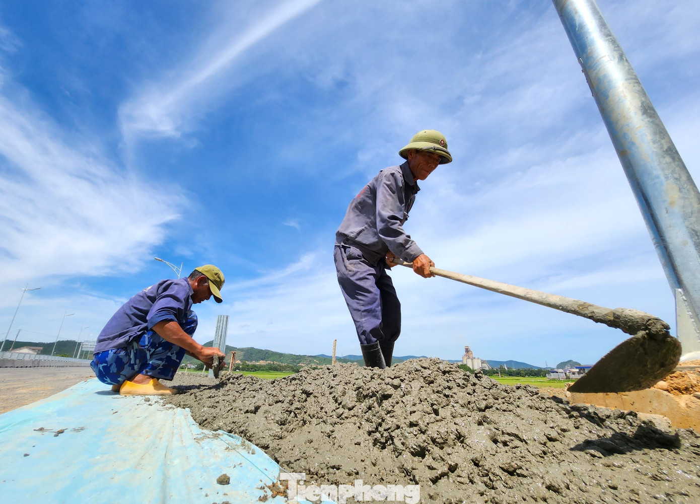 Làm việc xuyên trưa, nhóm công nhân đang thực hiện nốt phần đổ lề đường ngay nút giao ra vào đường 36 (TX. Hoàng Mai, Nghệ An).