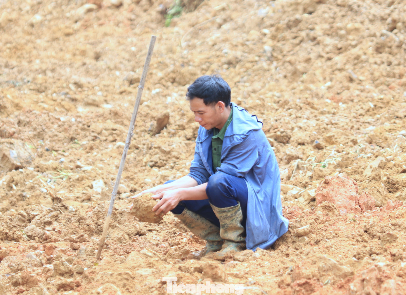 Giữa trưa, khi lực lượng chức năng nghỉ ngơi, anh Pôm vẫn đứng giữa bãi đất tan hoang, moi móc từng viên đá để mong được sớm tìm thấy em mình.