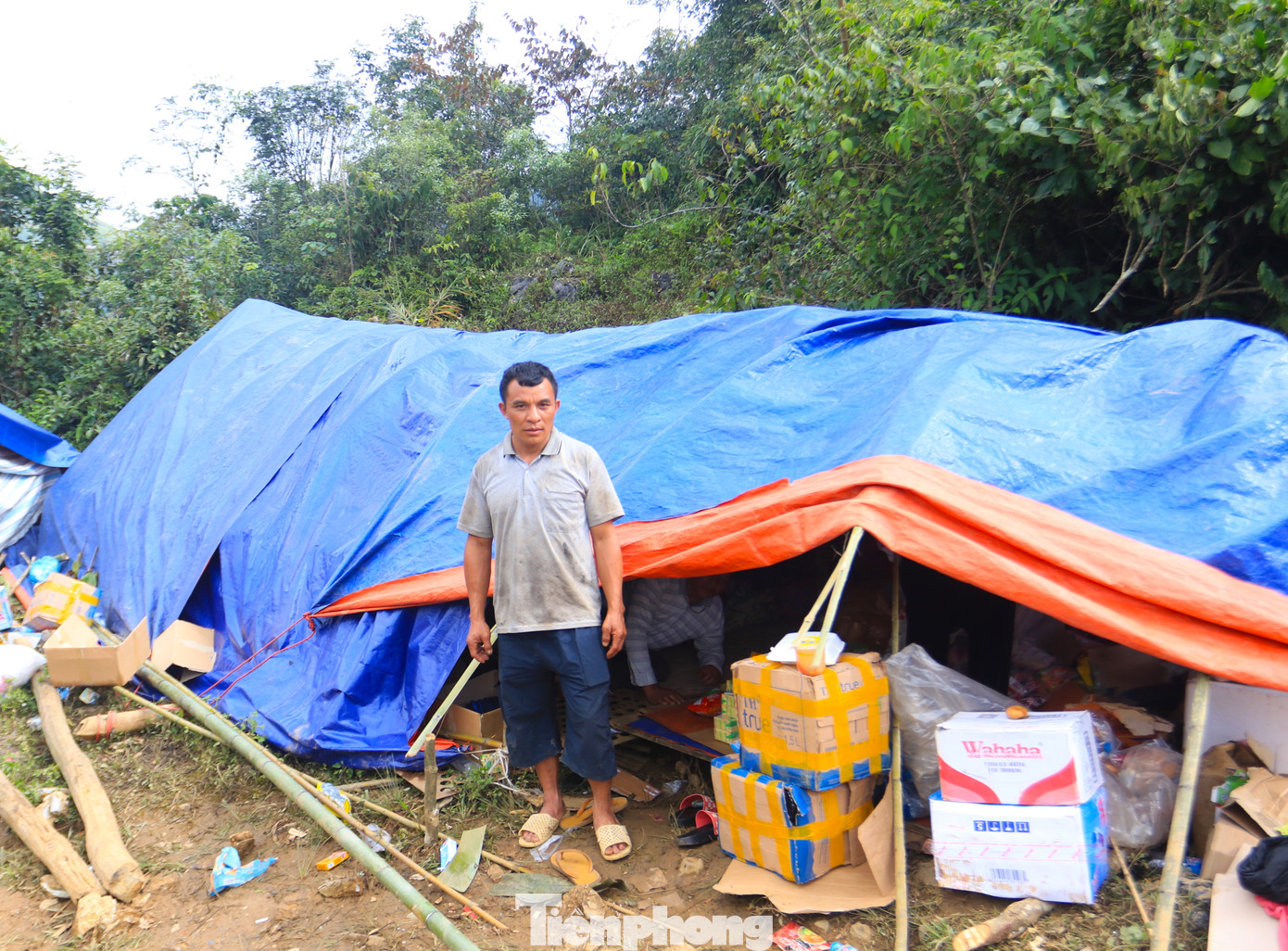 Gần 1 tuần trước, ngọn núi sau nhà sạt lở, lượng lớn đất đá ào xuống khiến bức tường nhà của ông Lý Dào Sinh (45 tuổi) đổ sập. Bên trong, nhiều tài sản bị hư hỏng, lợn gà cũng bị đất đá vùi lấp. Không còn nhà, ông Sinh theo hàng xóm đến khu Chạn Xá dựng lán ở tạm. Chiếc lán mới lợp rộng chừng 20m2 nhưng là nơi trú ngụ của gia đình ông Sinh và 3 hộ khác gồm con và 2 anh trai. 19 người chen chúc trong không gian chật hẹp nhưng ai cũng động viên nhau cùng cố gắng qua cơn hoạn nạn này.