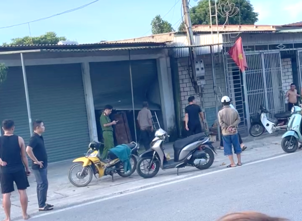 Người dân và công an đứng trước căn nhà nơi xảy ra vụ nổ kinh hoàng.