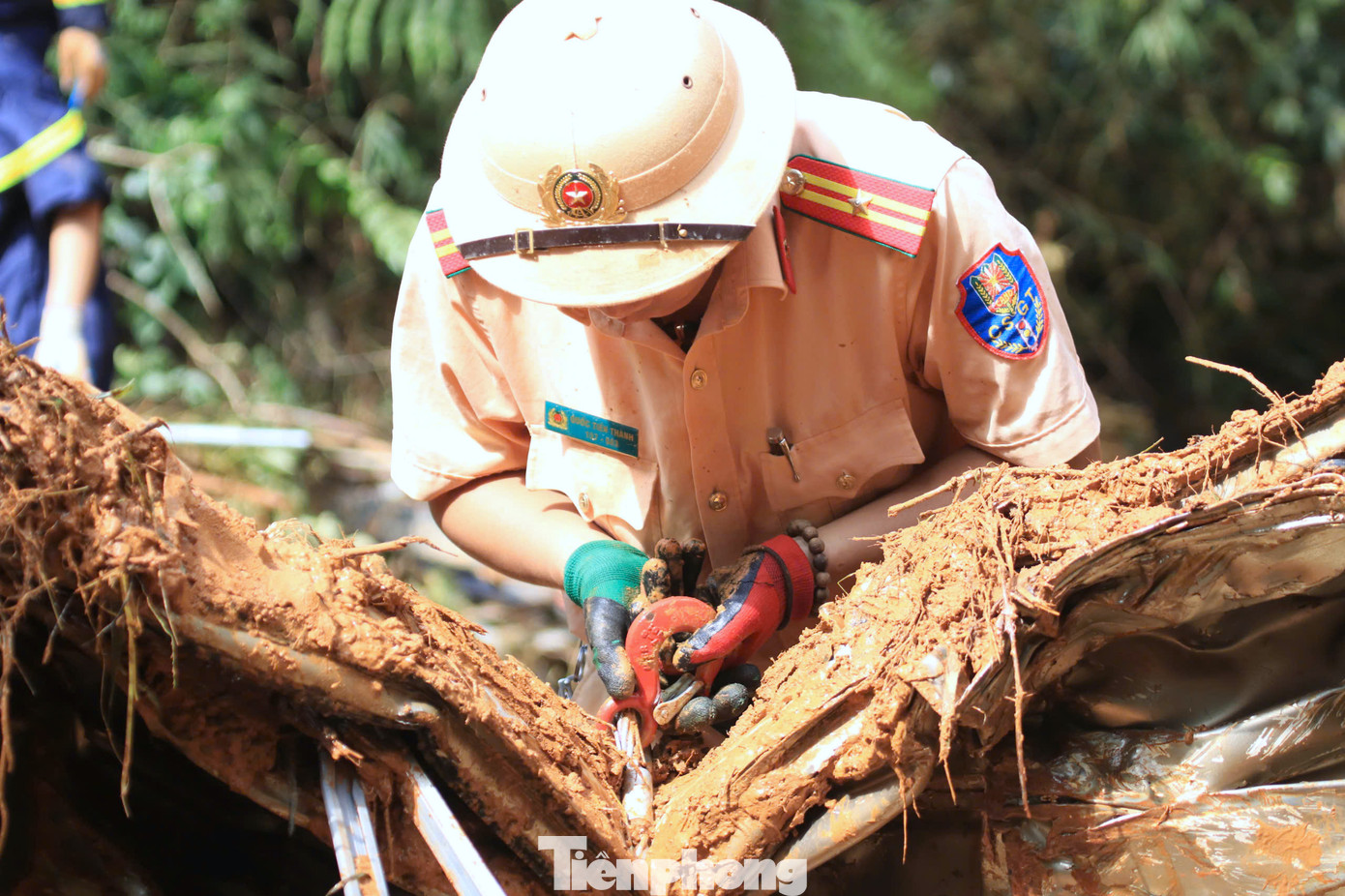 Thiếu tá Quốc Tiến Thành (áo vàng) tìm cách móc dây cáp vào các bộ phận xe khách để dùng tời tách các bộ phận ra ngoài, phục vụ việc tìm kiếm các nạn nhân.