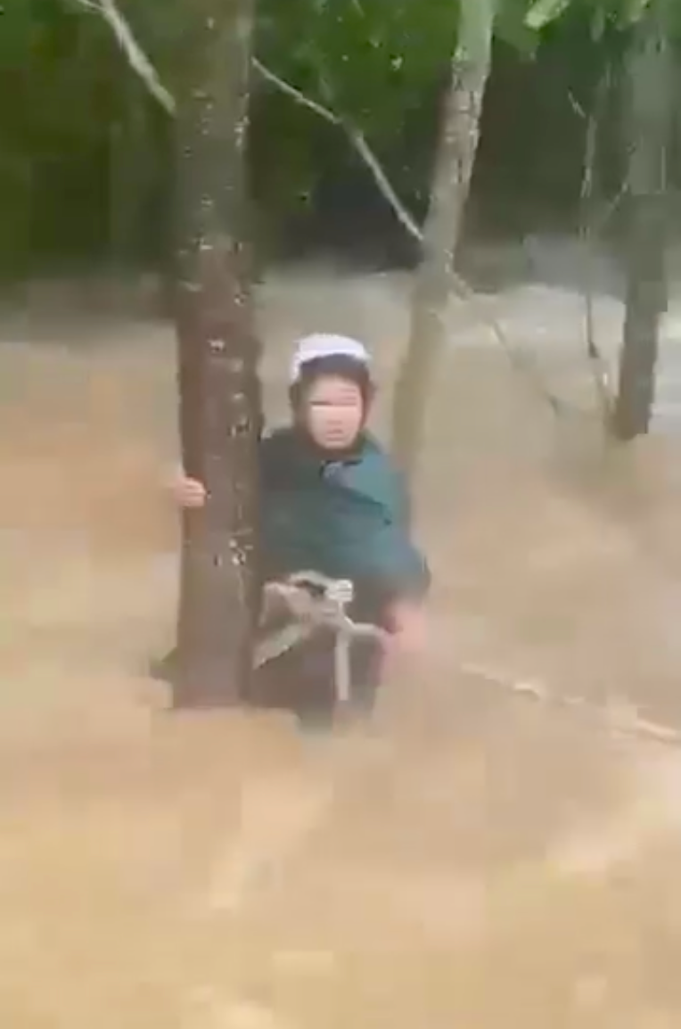 Bà Loan bị nước cuốn trôi và may mắn được người dân ném dây thừng cứu lên bờ an toàn.