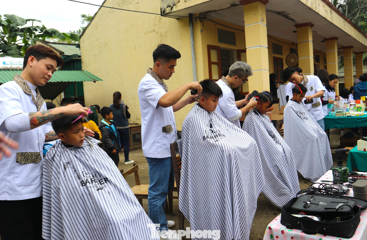 Song song với việc thăm khám, các em và người dân còn được những người thợ cắt tóc miễn phí.