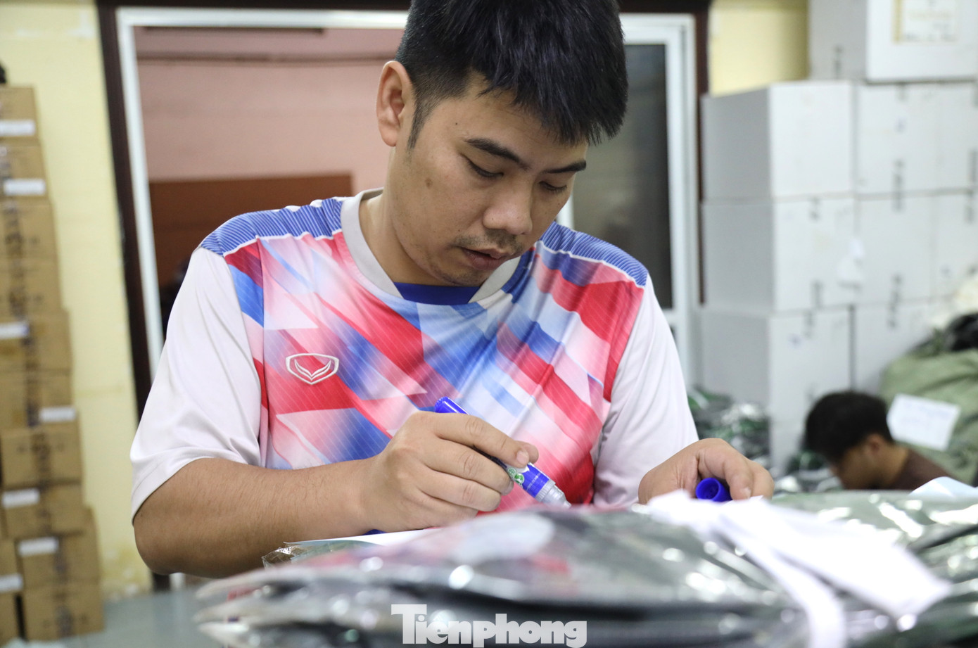 Tình nguyện viên cẩn thận ghi chép đầy đủ số lượng, phân loại trang phục cho vận động viên.