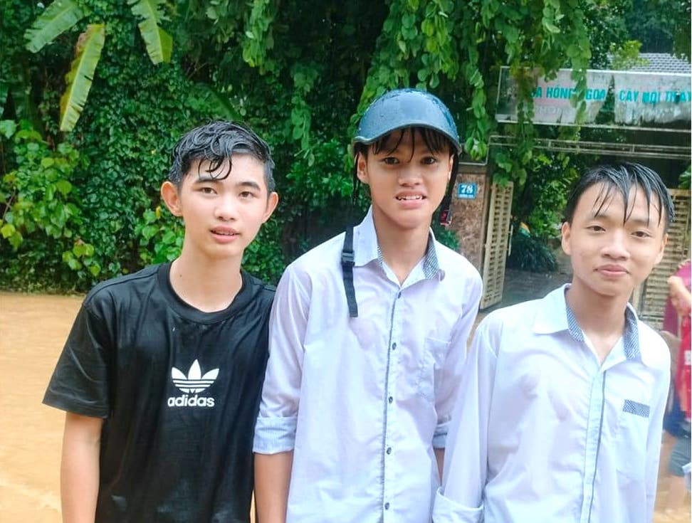 Các nam sinh thời điểm dầm mưa để cứu, giúp người trong mưa lũ.