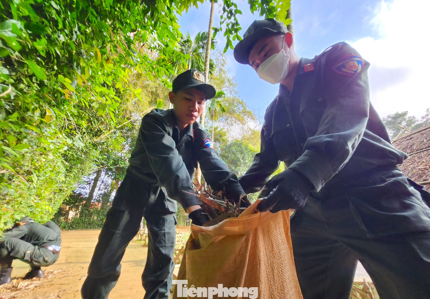 Quét dọn lá cây bờ rào nhà Bác Hồ và nhà tưởng niệm.