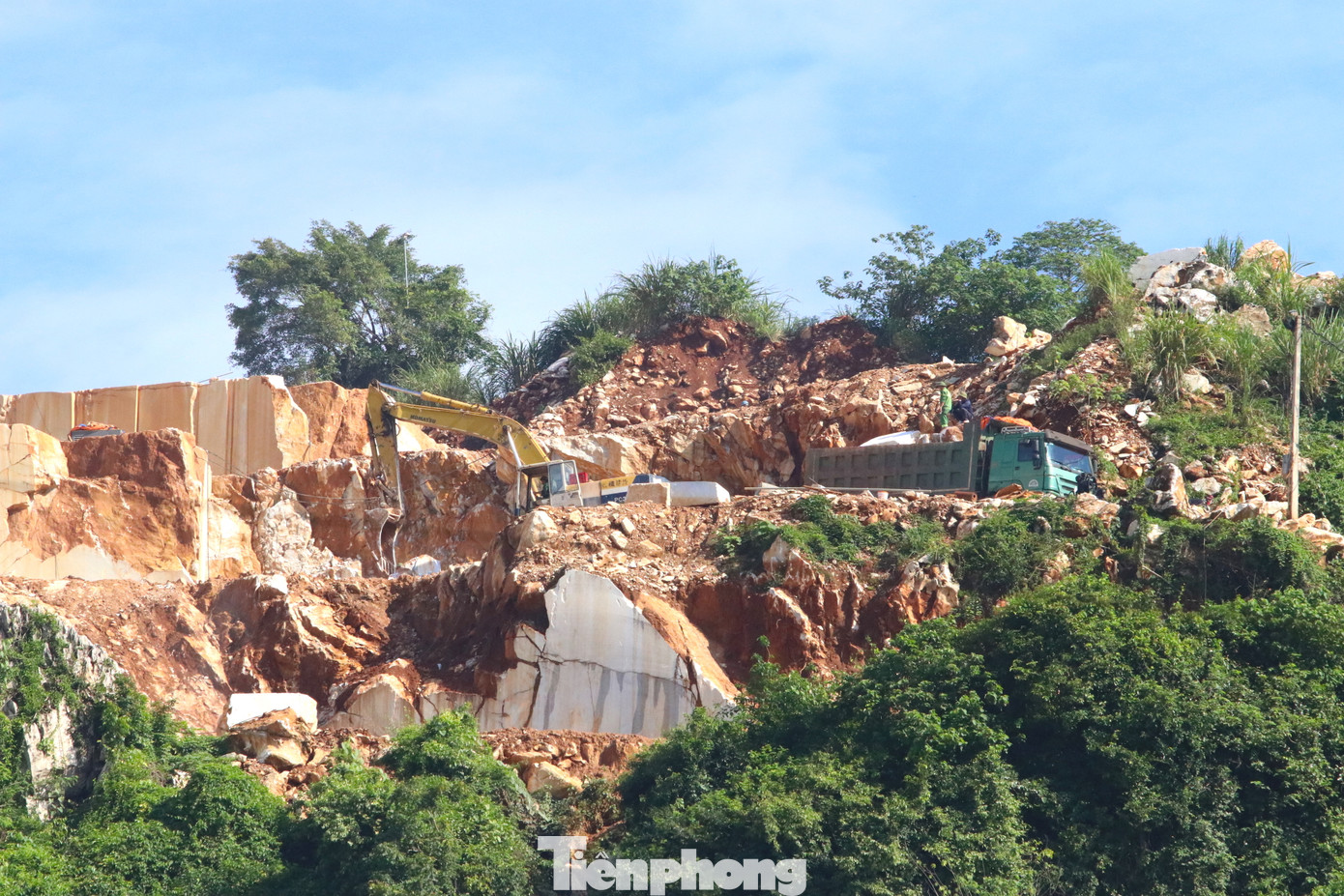 Công nhân cùng máy móc làm việc trên những mỏm núi cheo leo.