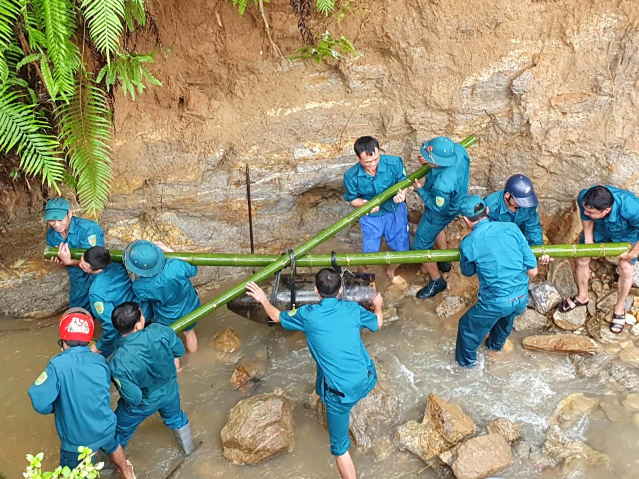 Dùng cây tre gánh vận chuyển quả bom đi tiêu hủy. Dùng cây tre gánh vận chuyển quả bom đi tiêu hủy.