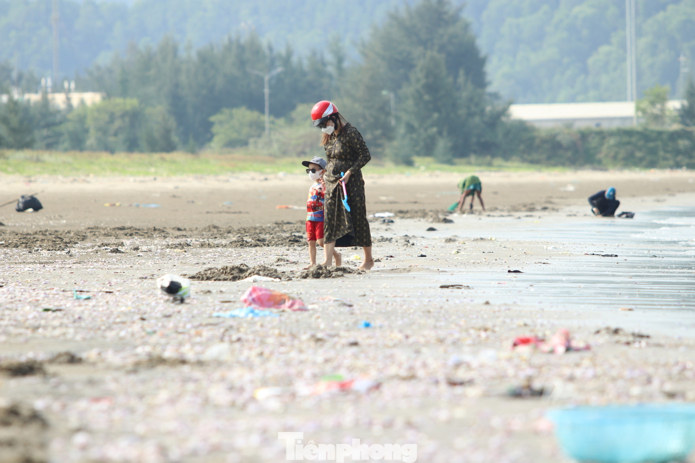 Nhiều phụ nữ dắt theo con nhỏ vừa dạo biển vừa nhặt ngao.