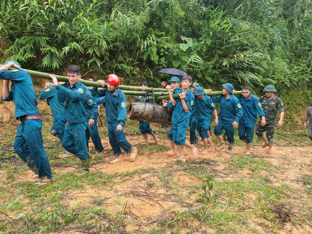Quả bom nặng hàng trăm kg được nhiều người gánh đi khỏi hiện trường. Quả bom nặng hàng trăm kg được nhiều người gánh đi khỏi hiện trường.