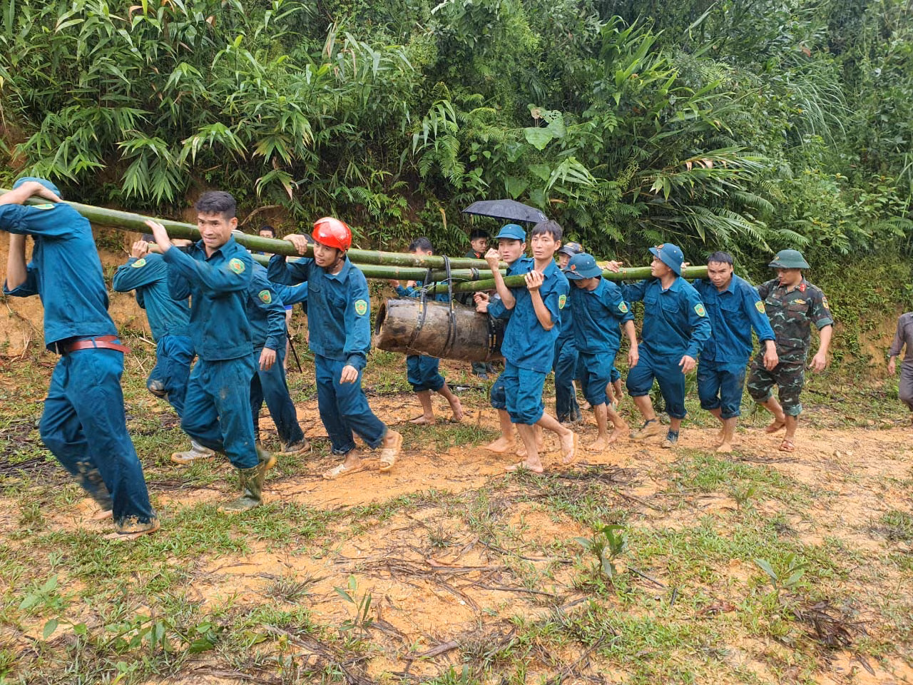 Quả bom nặng hàng trăm kg được nhiều người gánh đi khỏi hiện trường.