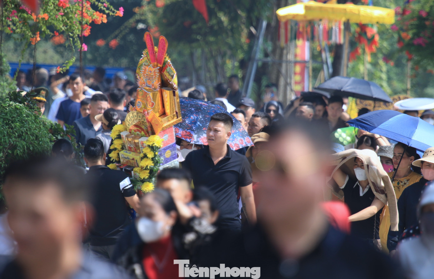 Trên tay du khách là những mâm lễ, voi, ngựa giấy để dâng lên Đền Ông Hoàng Mười.