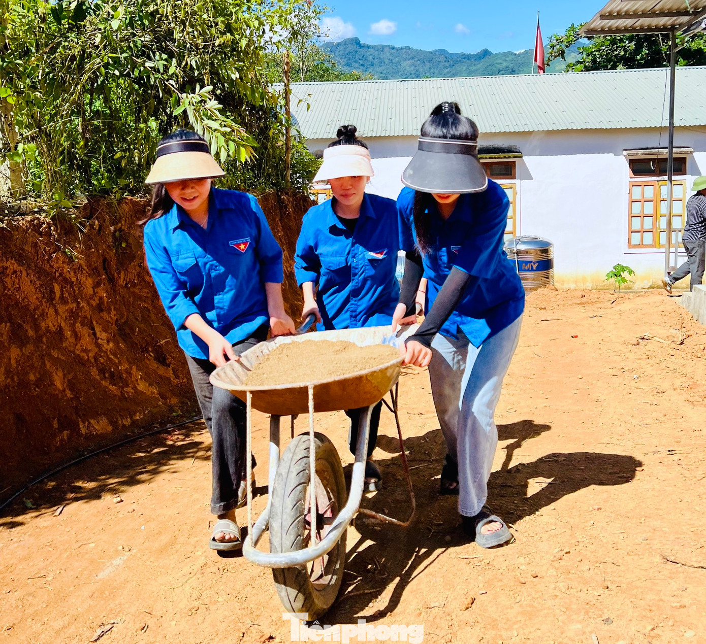Nhiều bạn nữ cùng đẩy xe cát lên dốc để phục vụ làm đường. Nhiều bạn nữ cùng đẩy xe cát lên dốc để phục vụ làm đường.