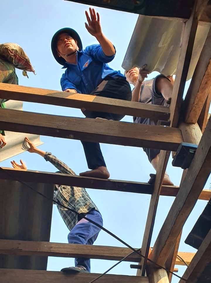 Các đoàn viên thanh niên nhiệt tình hỗ trợ người dân lợp lại mái ngói bất kể trời nắng nóng hay mưa.