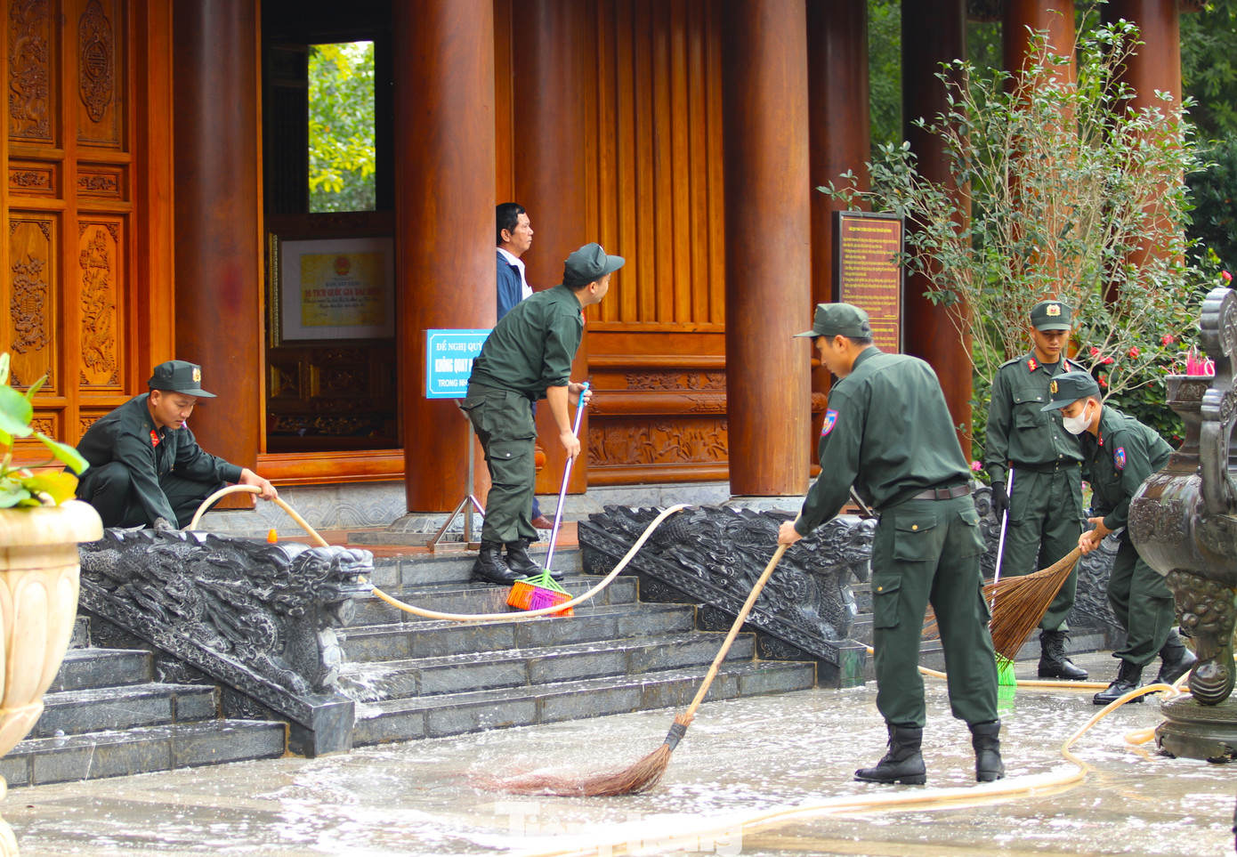 Quét dọn lá cây bờ rào nhà Bác Hồ và nhà tưởng niệm.