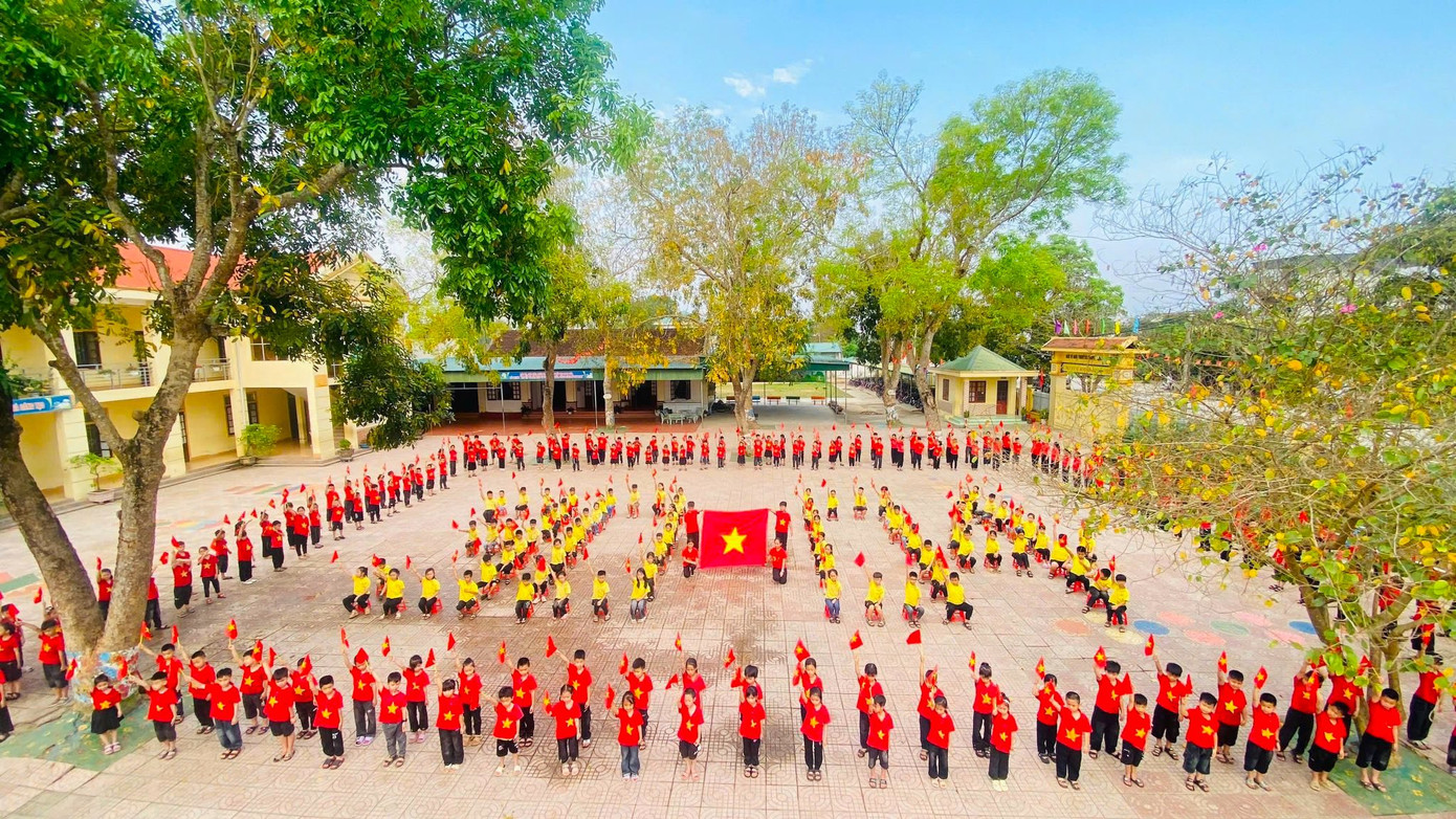 Các em nhỏ trường Tiểu học Long Sơn (thị xã Thái Hòa, Nghệ An) xếp hình ngày 30/4 cùng lá cờ đỏ sao vàng.