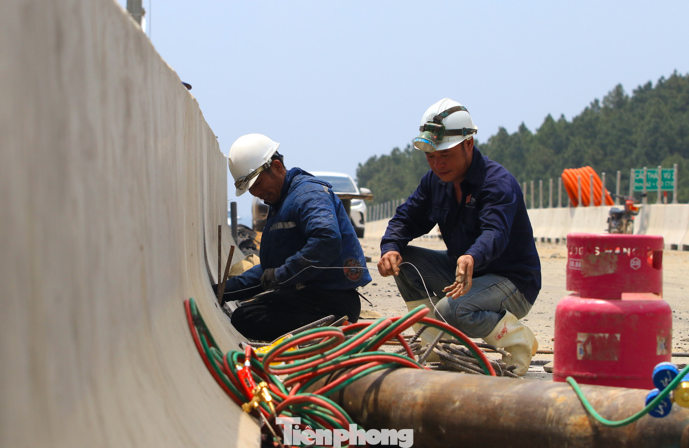 Các công nhân đang khẩn trương lắp đặt hệ thống đèn điện trên đường.