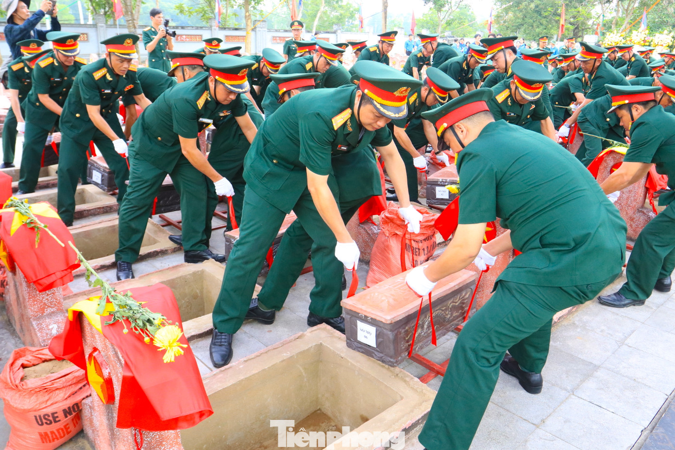 Các cán bộ chiến sỹ trang trọng thực hiện nghi thức an táng các anh hùng liệt sỹ.