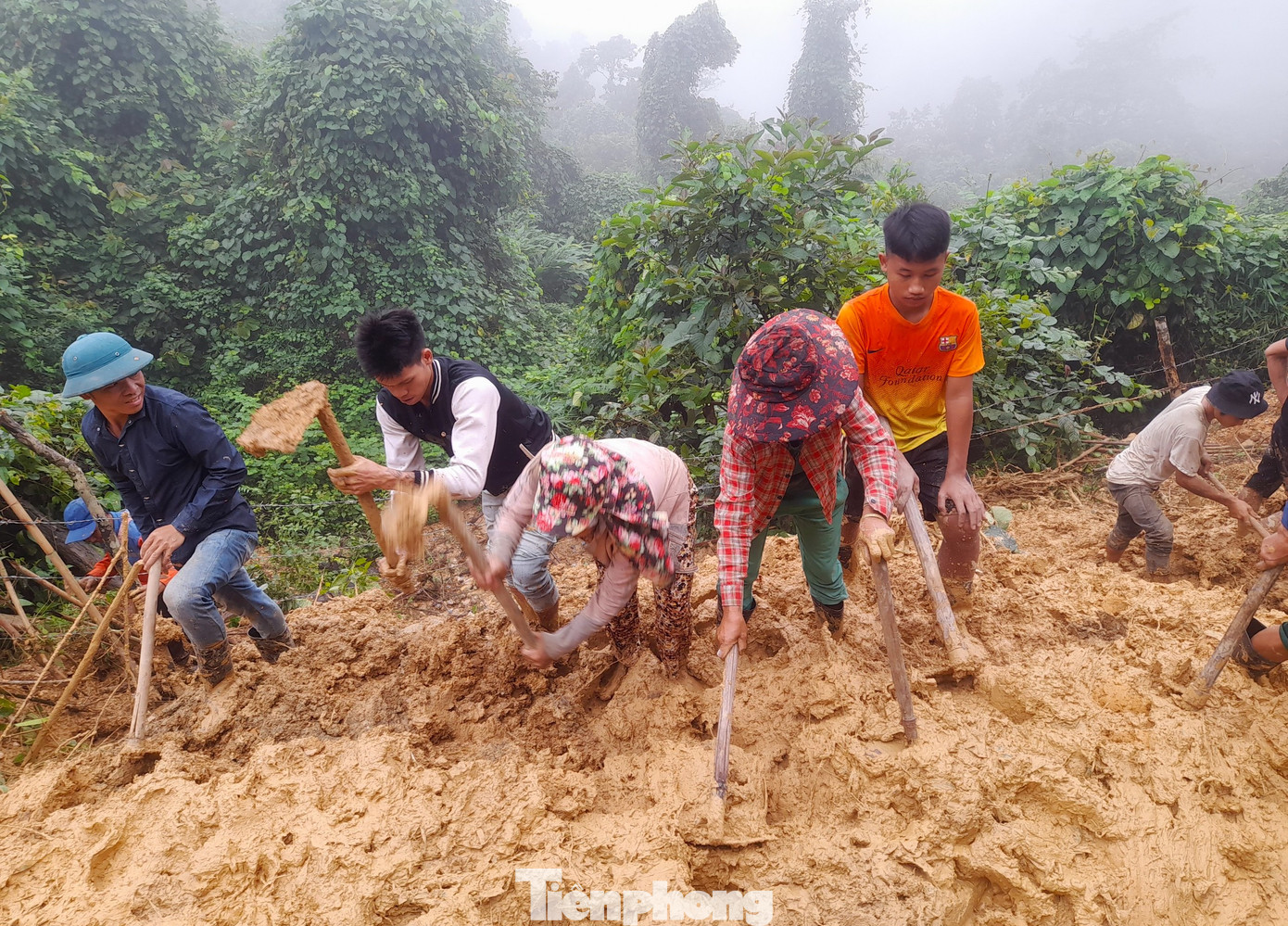 Người dân được huy động cào vét bùn sạt lở để thông đường giao thông cho bà con đi lại.