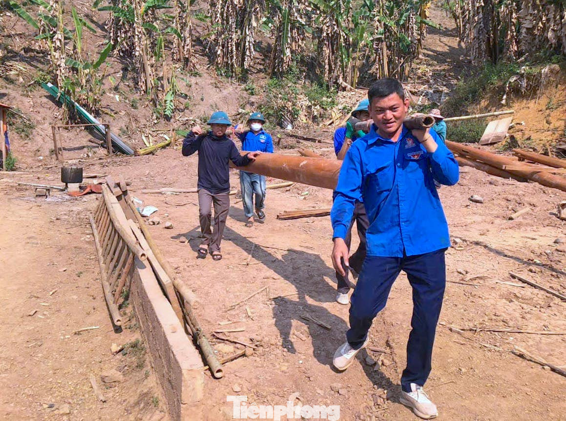 Thời tiết nắng nóng nhưng các đoàn viên thanh niên vẫn miệt mài vác cột, hỗ trợ người dân dựng nhà.