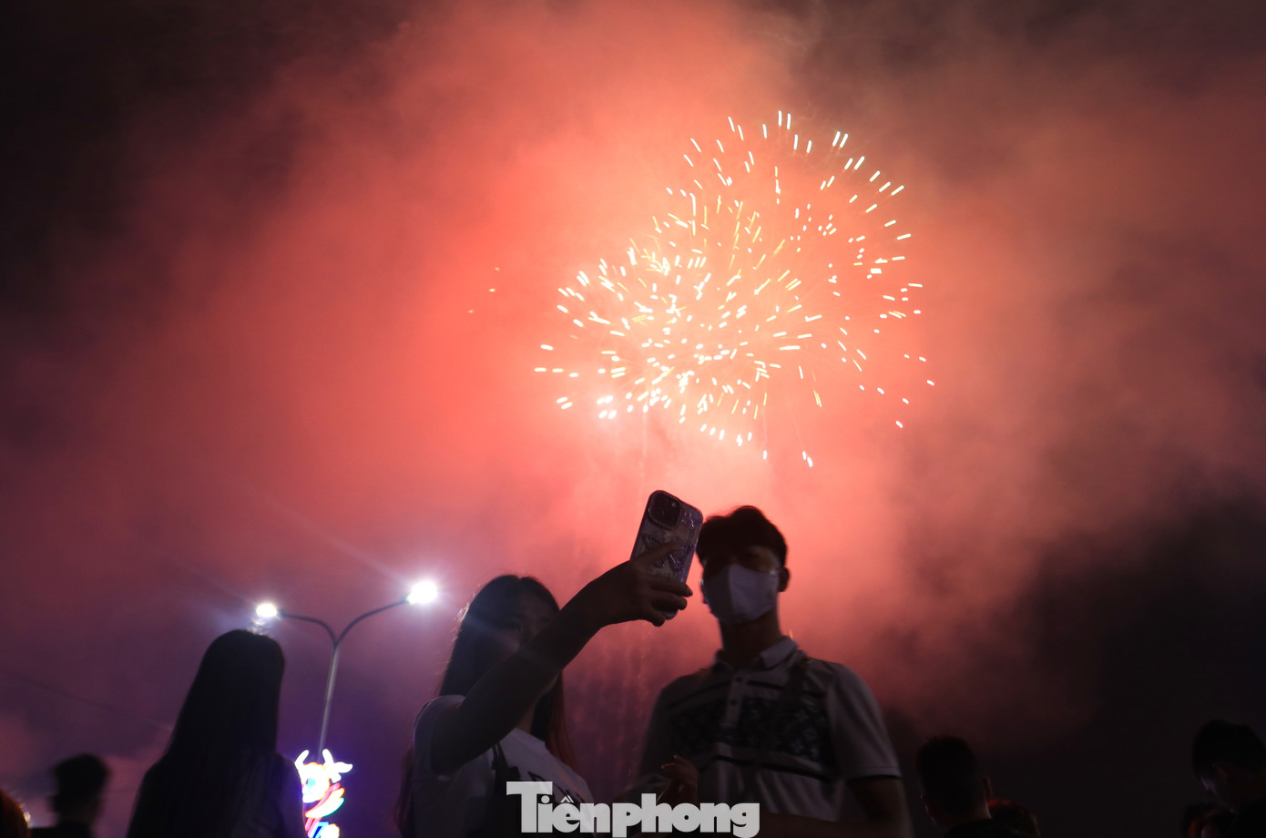Nhiều cặp đôi tranh thủ ngắm pháo hoa hoặc dùng điện thoại ghi lại khoảnh khắc bên nhau dưới màn pháo hoa rực rỡ.