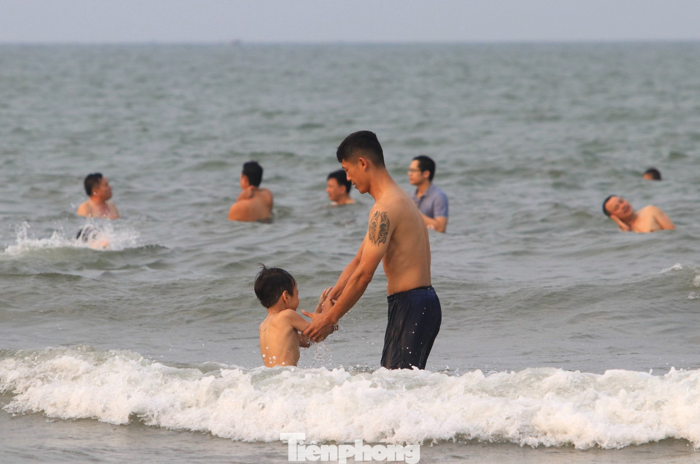 Dưới nước, du khách tắm mát và thích thú vui đùa cùng sóng biển. Dưới nước, du khách tắm mát và thích thú vui đùa cùng sóng biển.