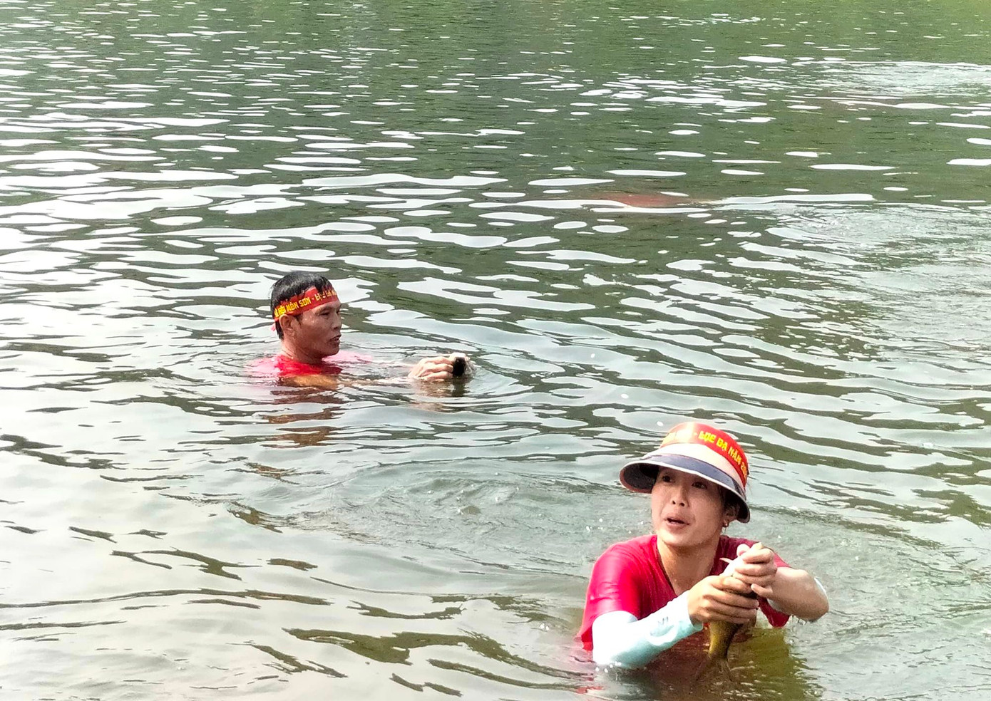 Bắt được cá, những người dưới nước và trên bờ đều hò reo cổ vũ.