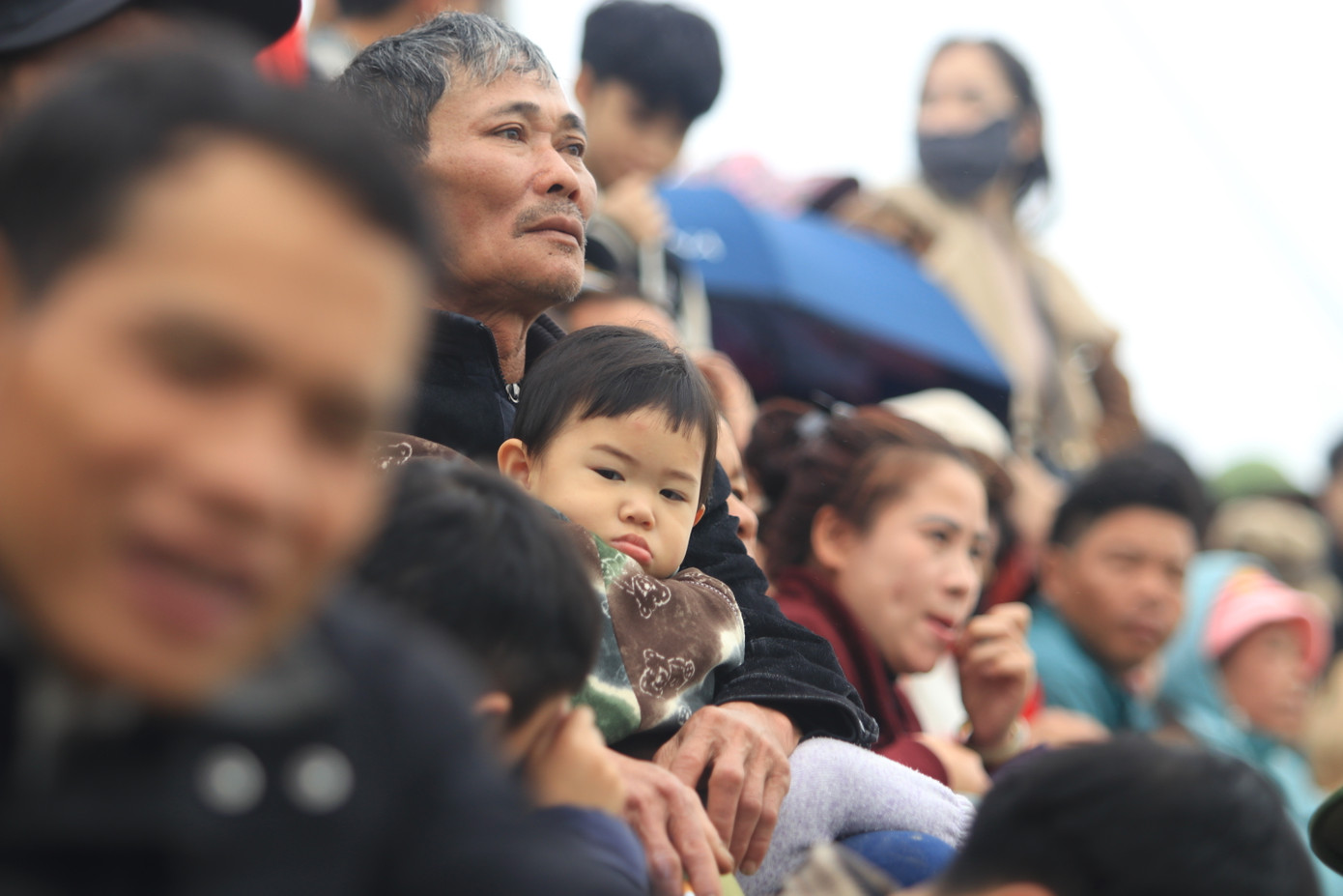 Nhiều em nhỏ được ông bà, bố mẹ dẫn ra xem hội đua thuyền.