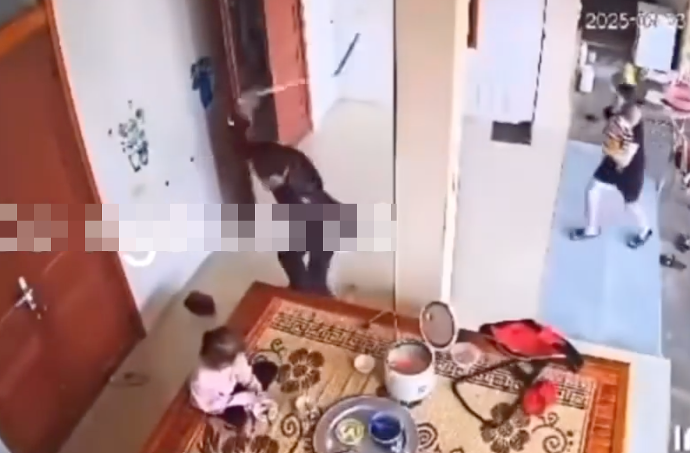 Người đàn ông cầm cây gậy dài đánh vào con nhỏ đang ngồi trước mâm cơm. (Ảnh cắt từ video clip). Người đàn ông cầm cây gậy dài đánh vào con nhỏ đang ngồi trước mâm cơm. (Ảnh cắt từ video clip).